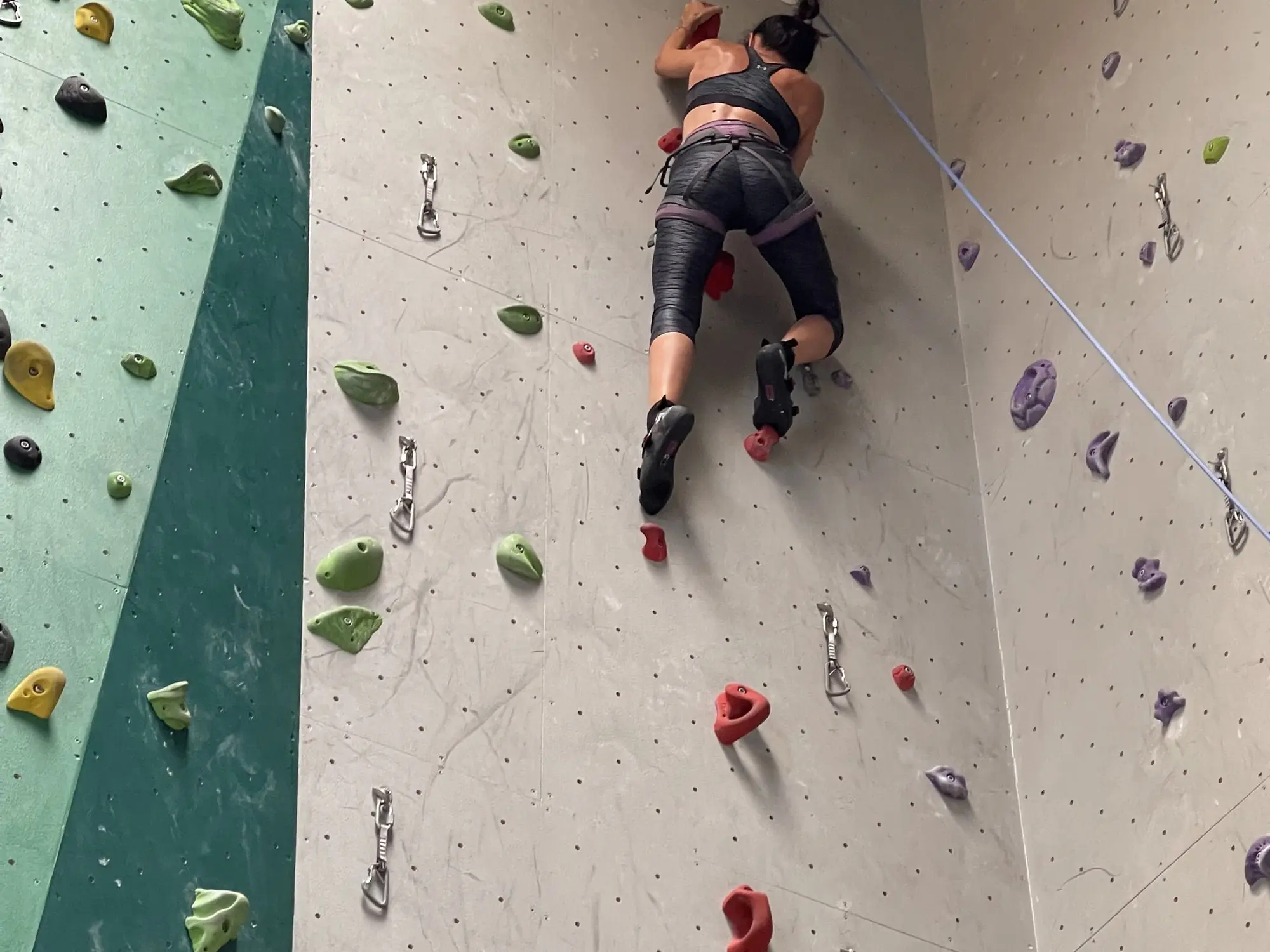 Une grimpeuse sur le mur d'escalade du Palais de Megève
