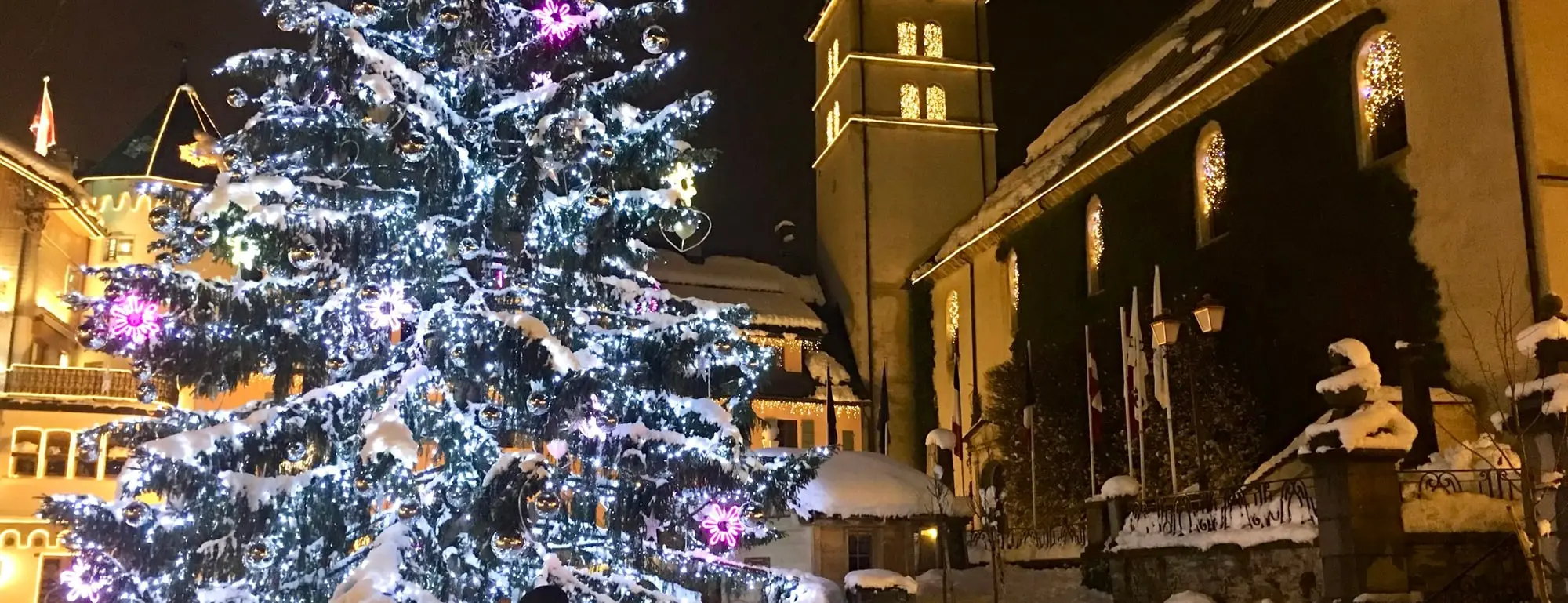 Le grand sapin de Noël illuminé devant l'église de Megève, la nuit