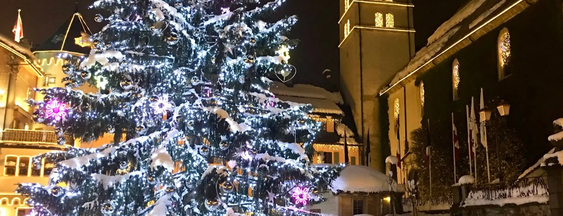 Le grand sapin de Noël illuminé devant l'église de Megève, la nuit