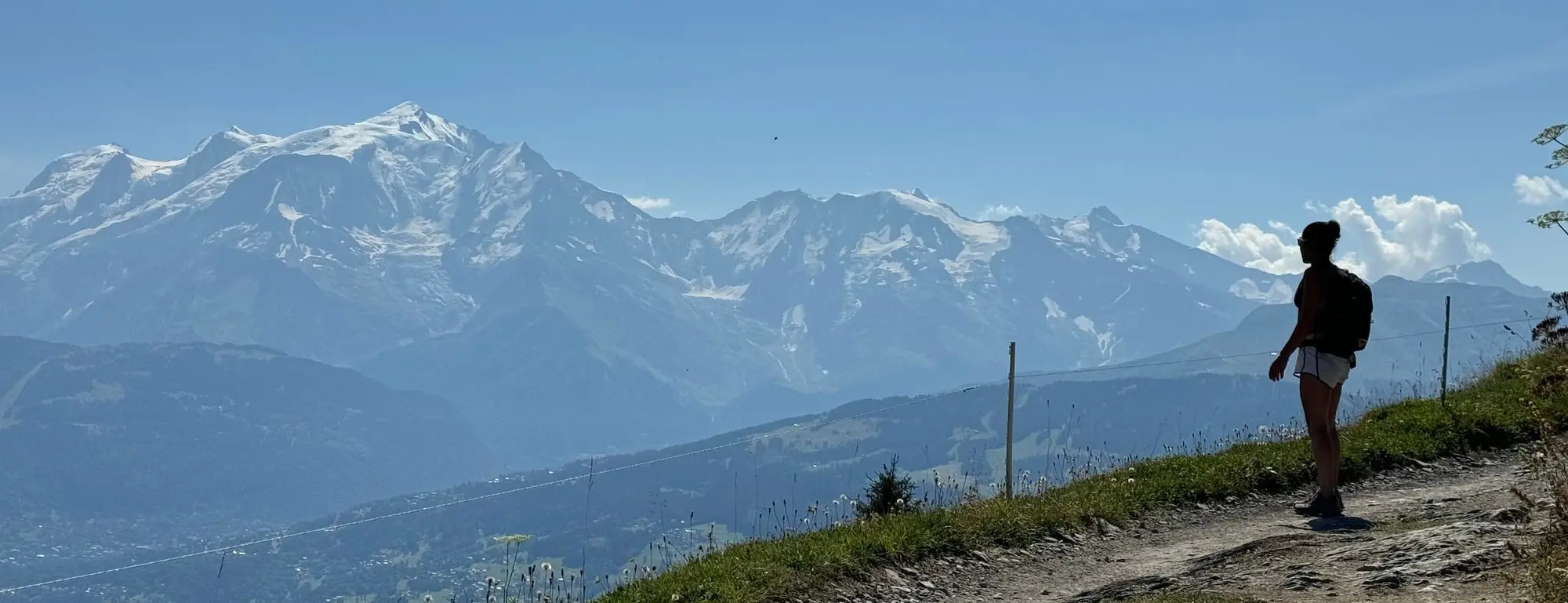 Une randonneuse face à la chaîne du Mont-Blanc, sur un chemin de crête