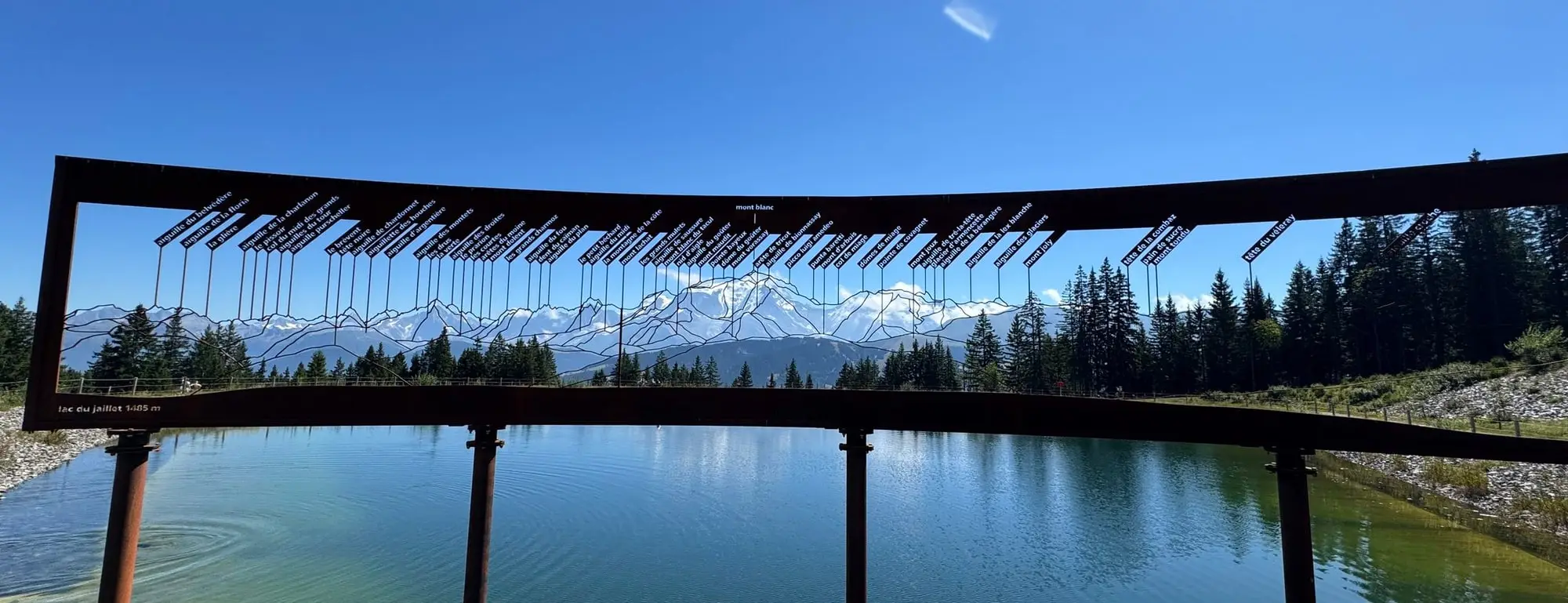 Le lac du Jaillet à travers le cadre en bois du belvédère, face à la chaîne du Mont-Blanc