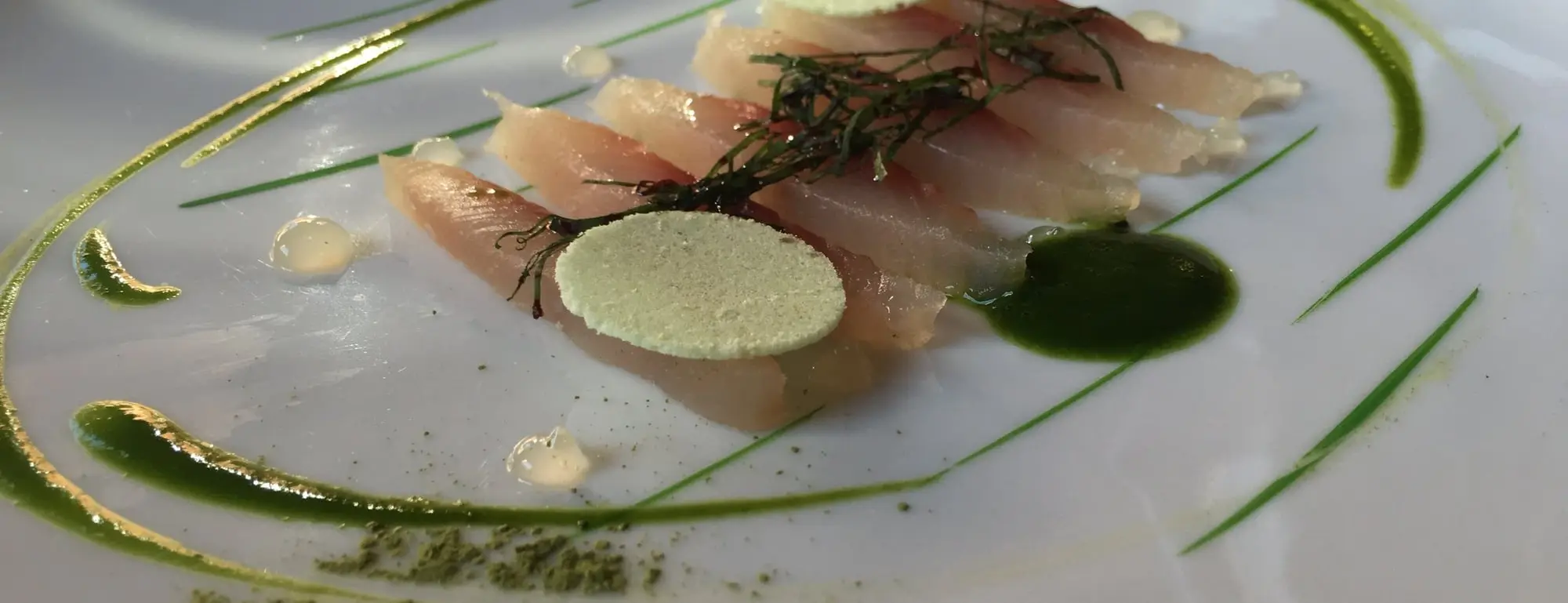 Une assiette de poisson cru, herbes et condiments, dans un restaurant près de Megève