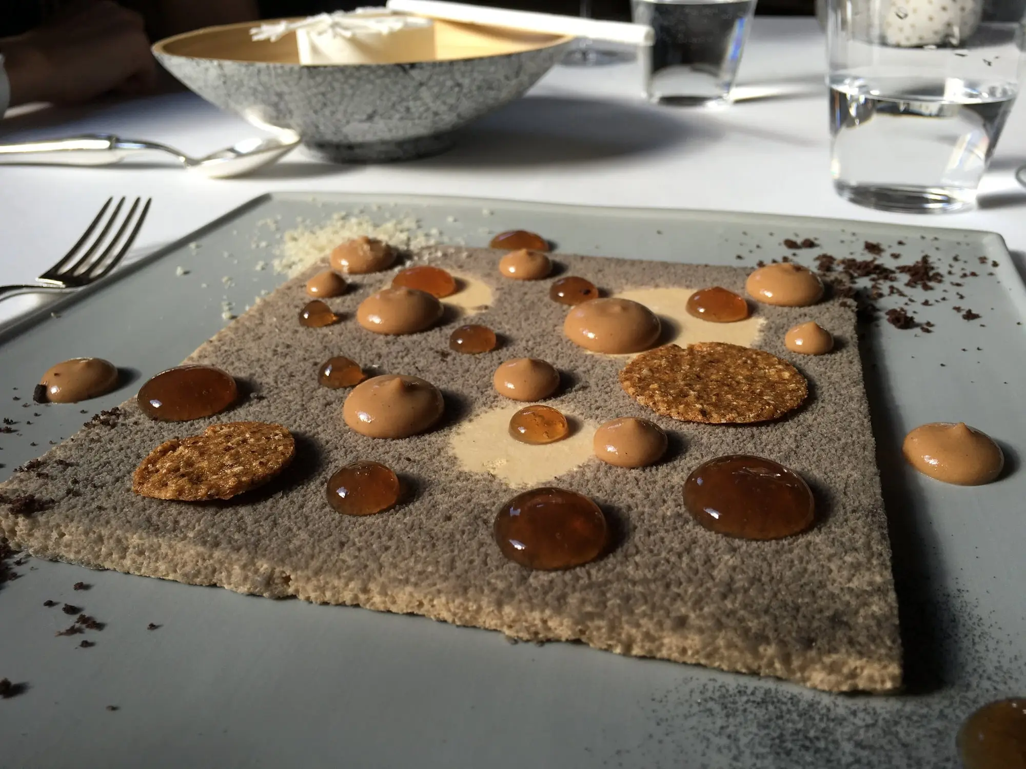 Un dessert au chocolat en points et en éclats, sur une plaque d'ardoise