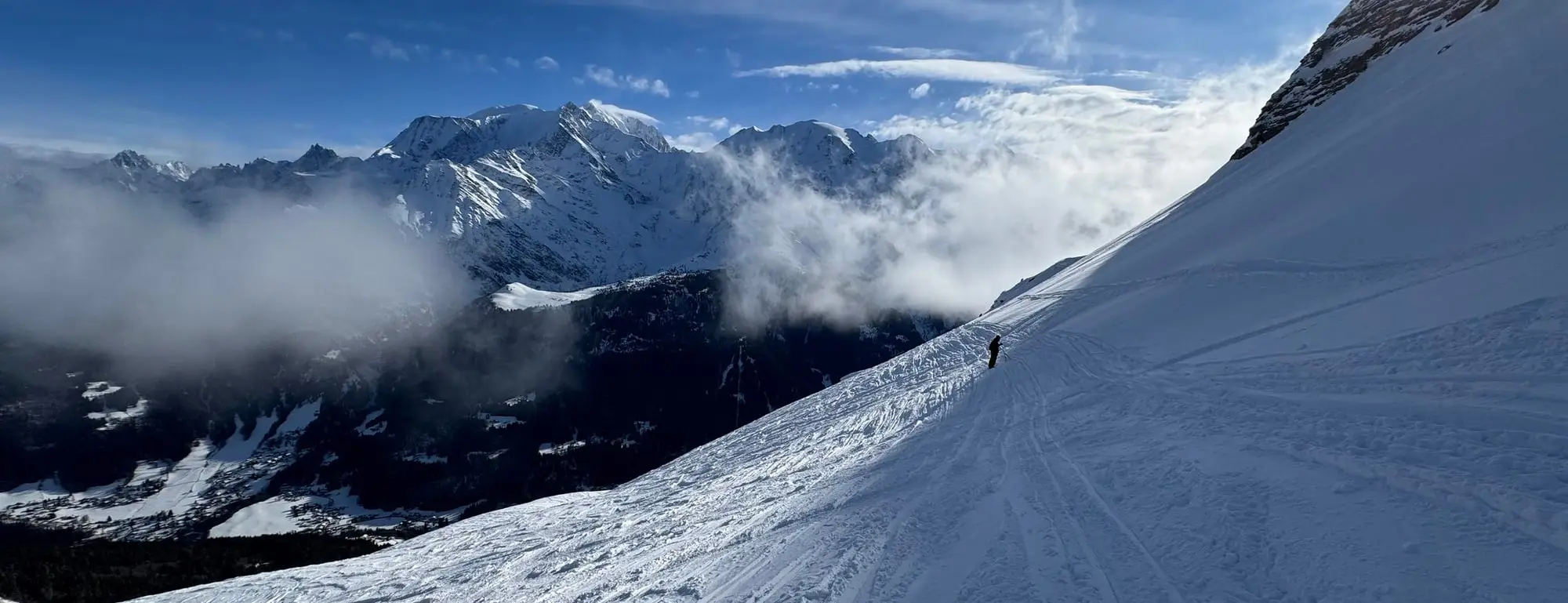 Une piste au soleil, face à la mer de nuages et aux sommets