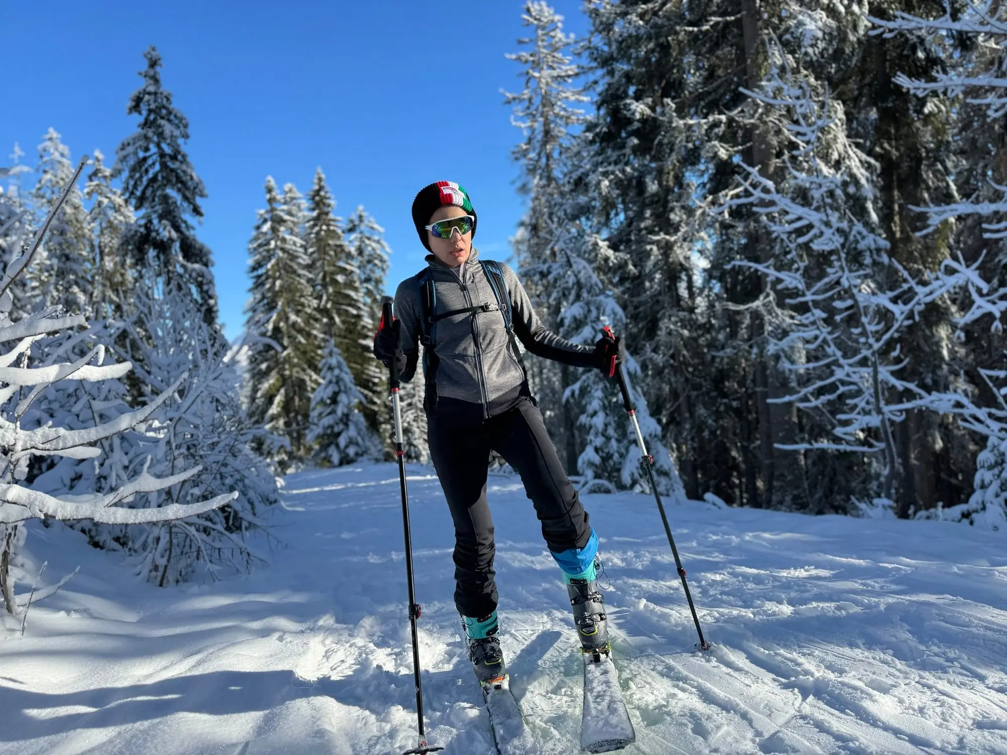 Une skieuse de randonnée dans la forêt enneigée