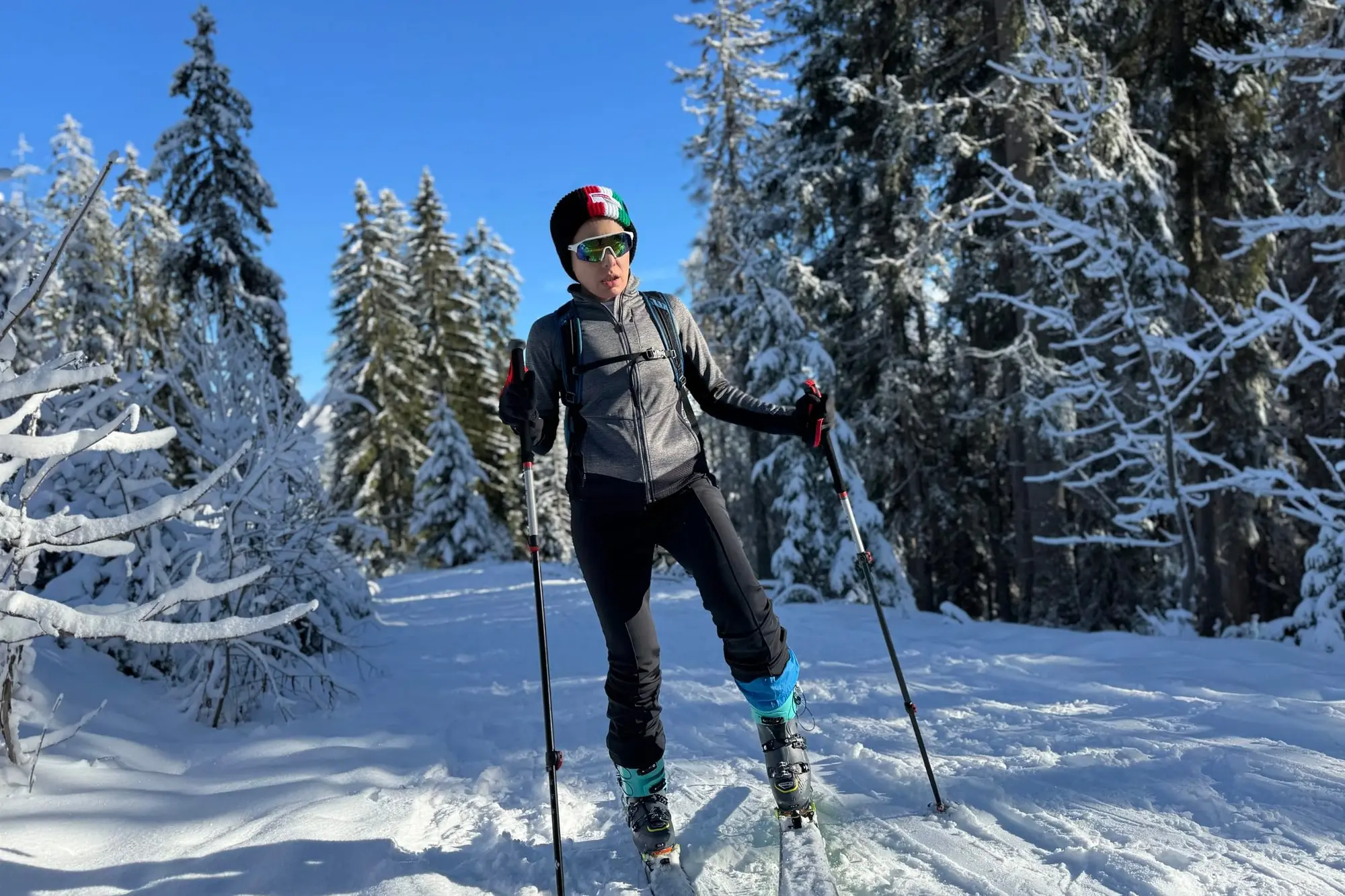Une skieuse de randonnée dans la forêt enneigée