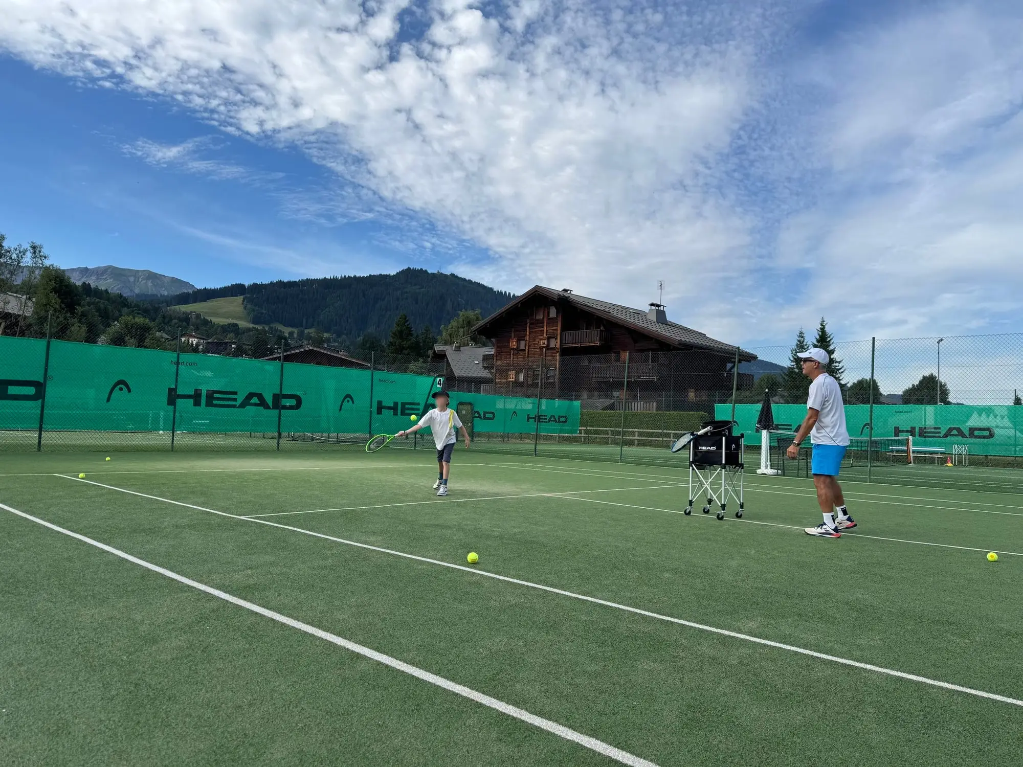 Les courts de tennis de Megève, chalet et montagnes derrière
