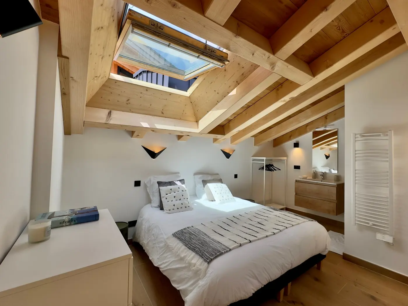 La chambre blanche sous les poutres et la fenêtre de toit