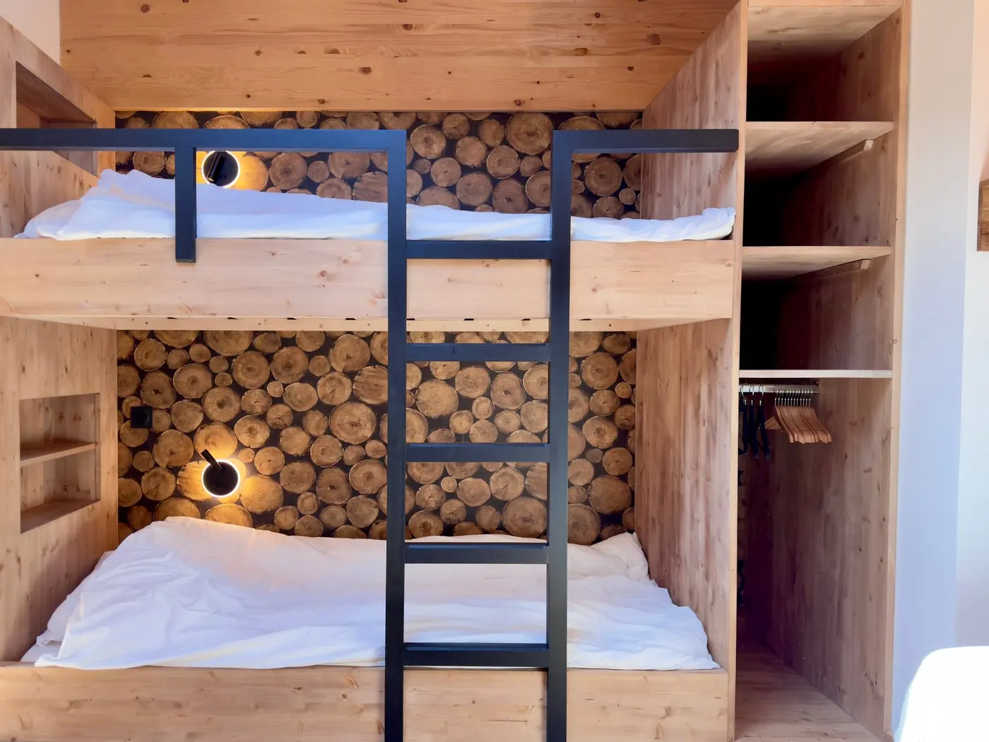 Les lits superposés de la chambre cabane, adossés au mur de rondins