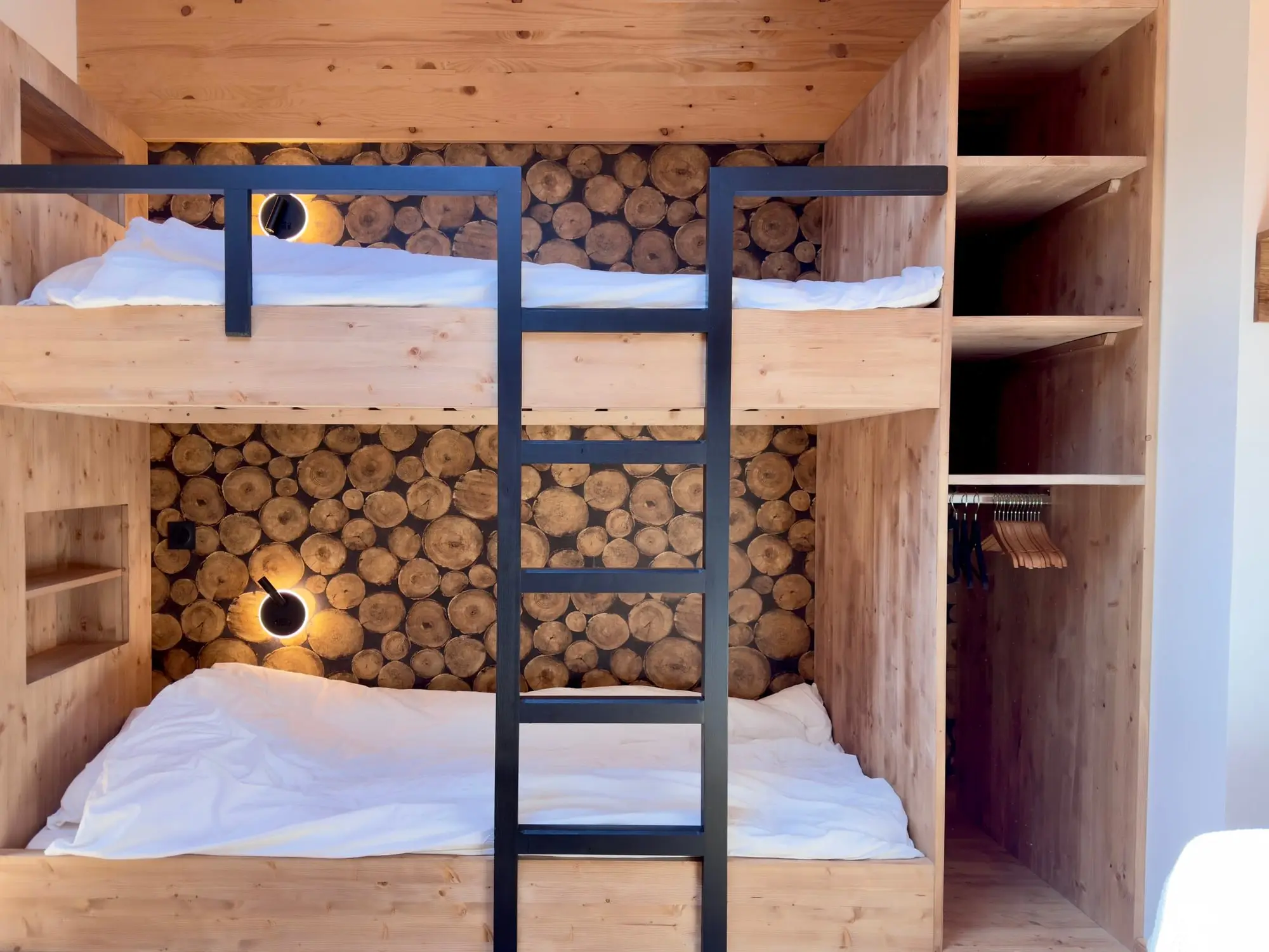 Les lits superposés de la chambre cabane, adossés au mur de rondins