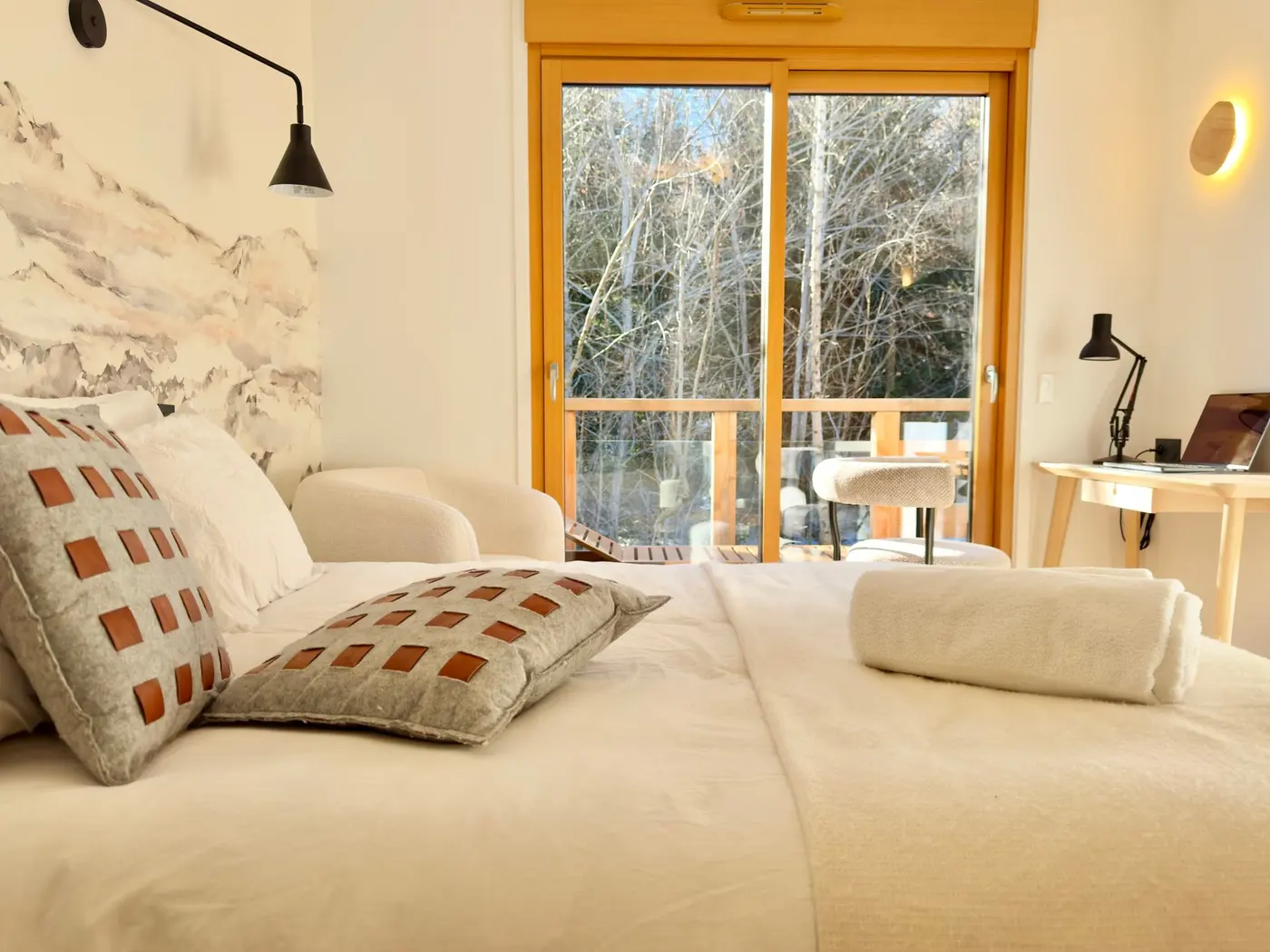 Le lit de la chambre forêt face à la baie sur la terrasse