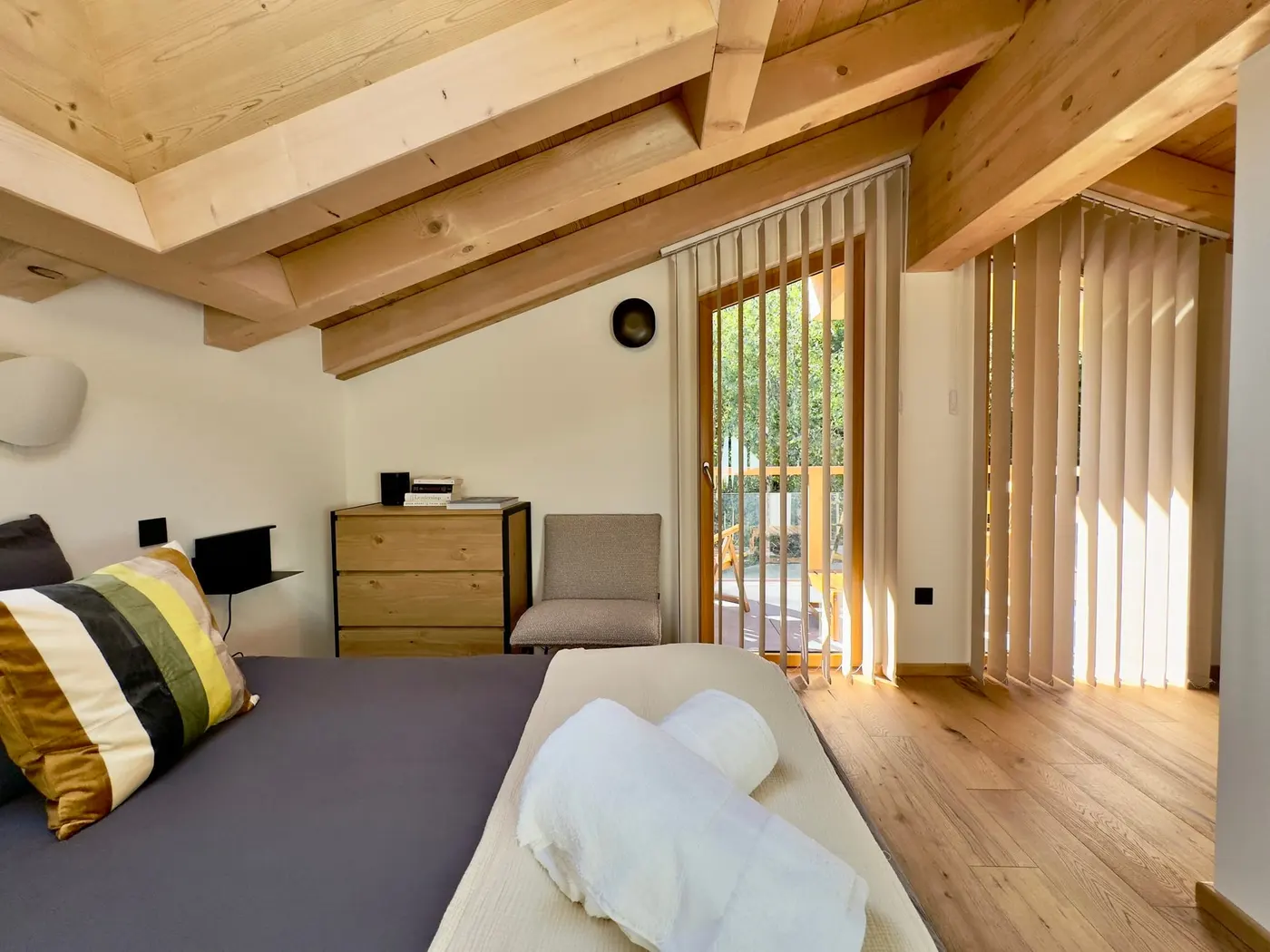 La chambre Mont-Blanc sous la charpente, lit double et porte-fenêtre sur le balcon