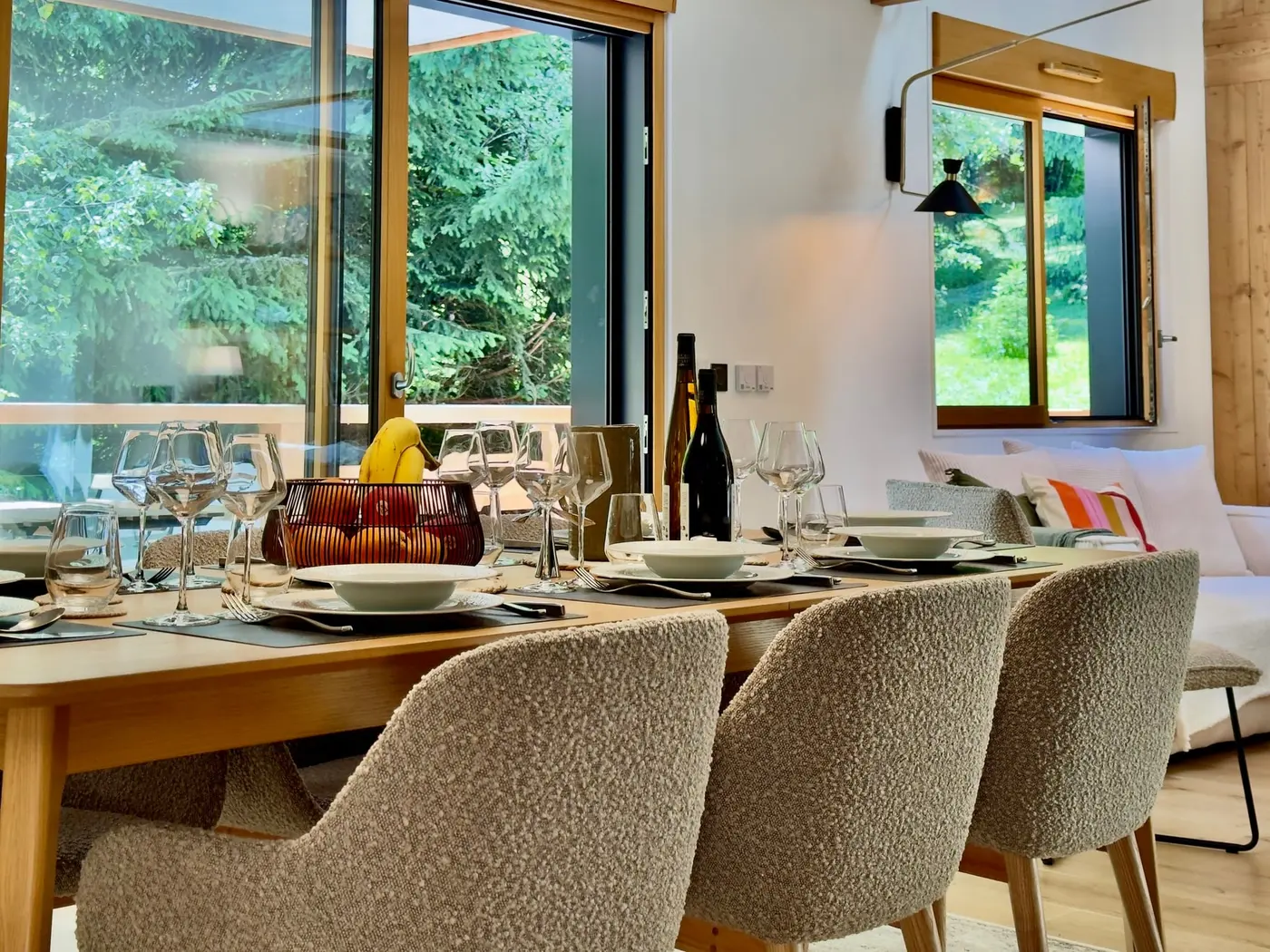 La table dressée devant les baies ouvertes sur la forêt