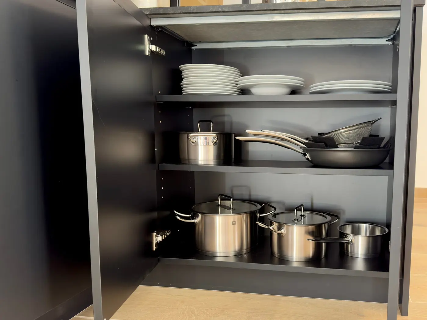 Un placard de la cuisine : vaisselle, casseroles et poêles