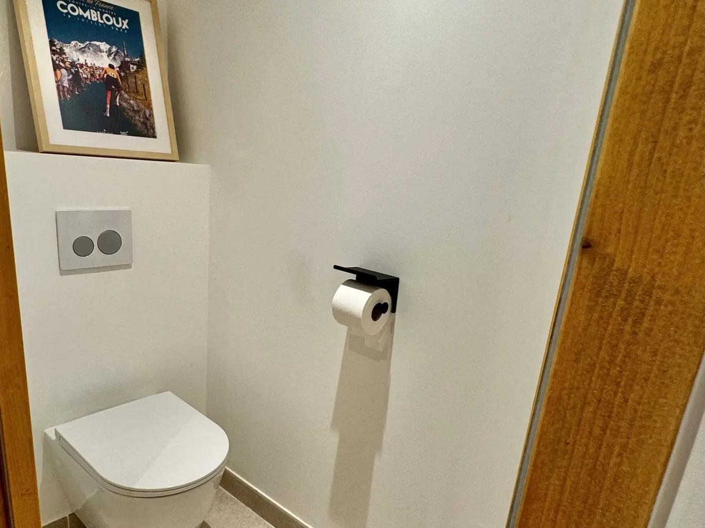 Le WC séparé du rez-de-chaussée, lave-mains et affiche de Combloux