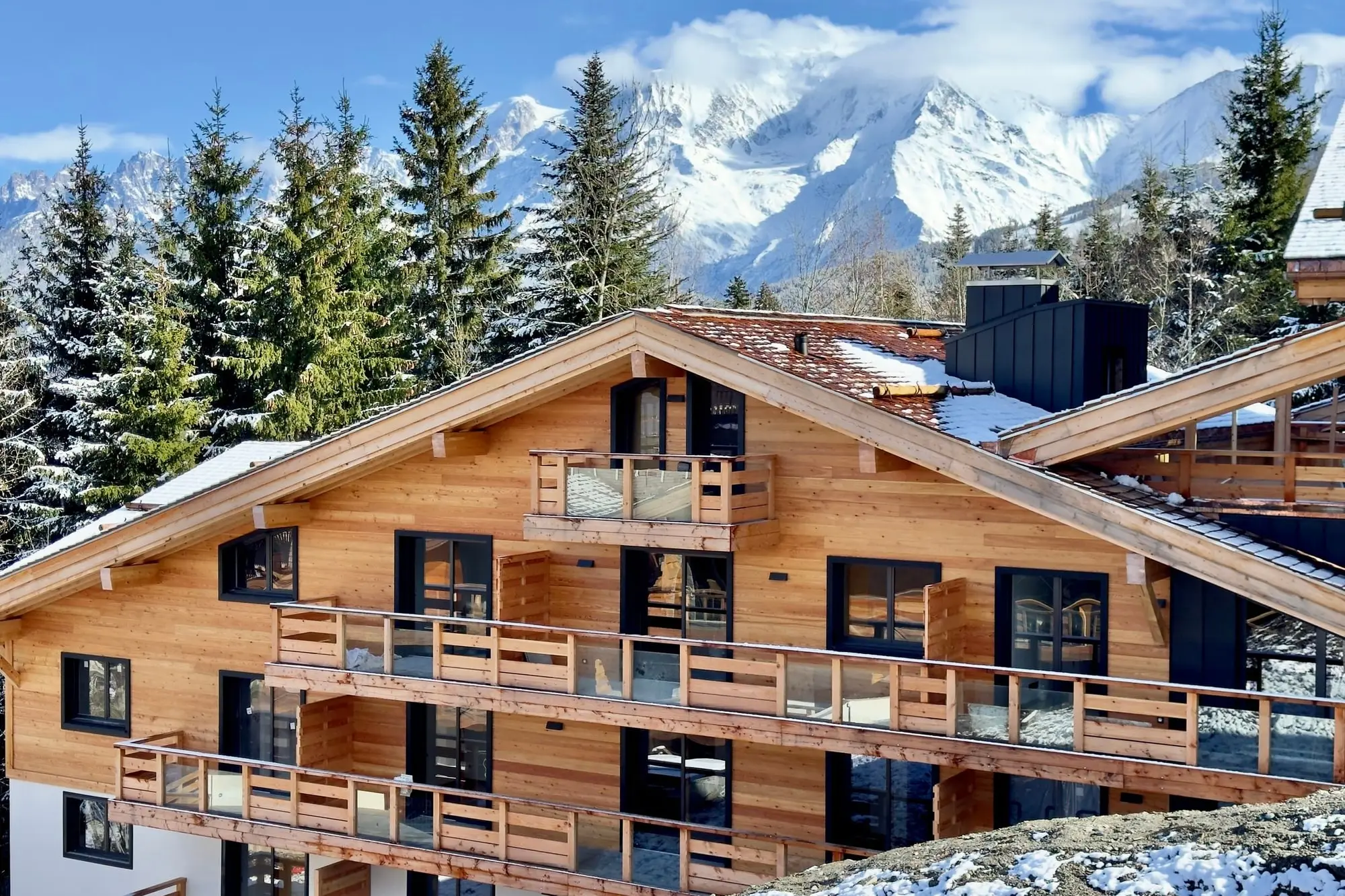 La façade de la résidence en hiver, le massif du Mont-Blanc derrière