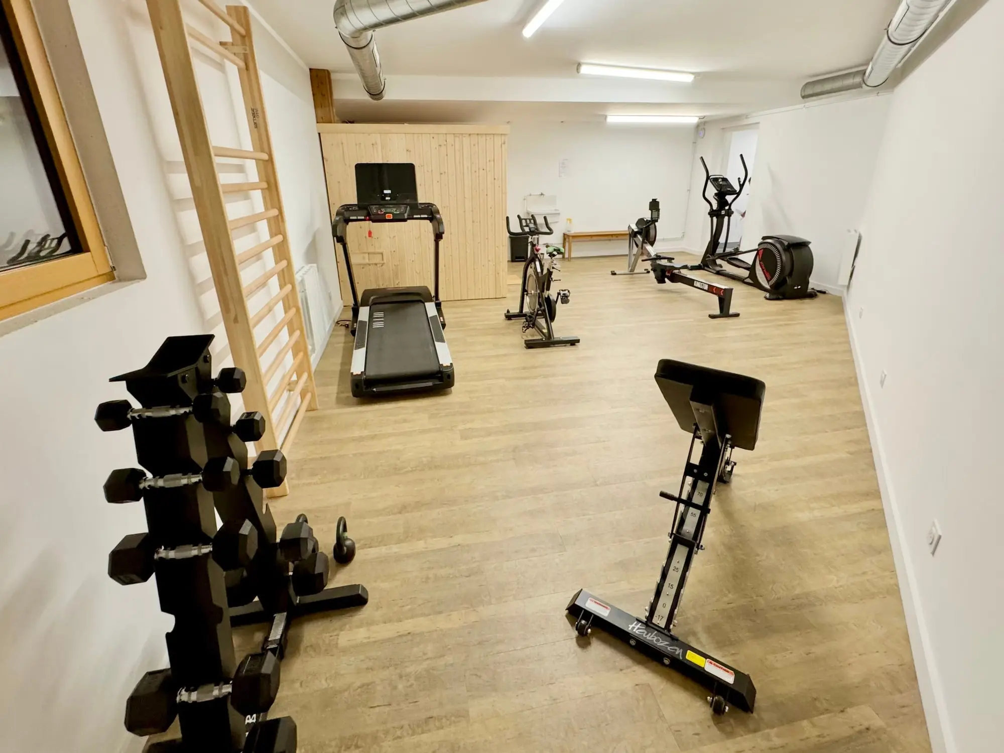 Der Fitnessraum der Wohnanlage: Laufband, Fahrräder und Hanteln