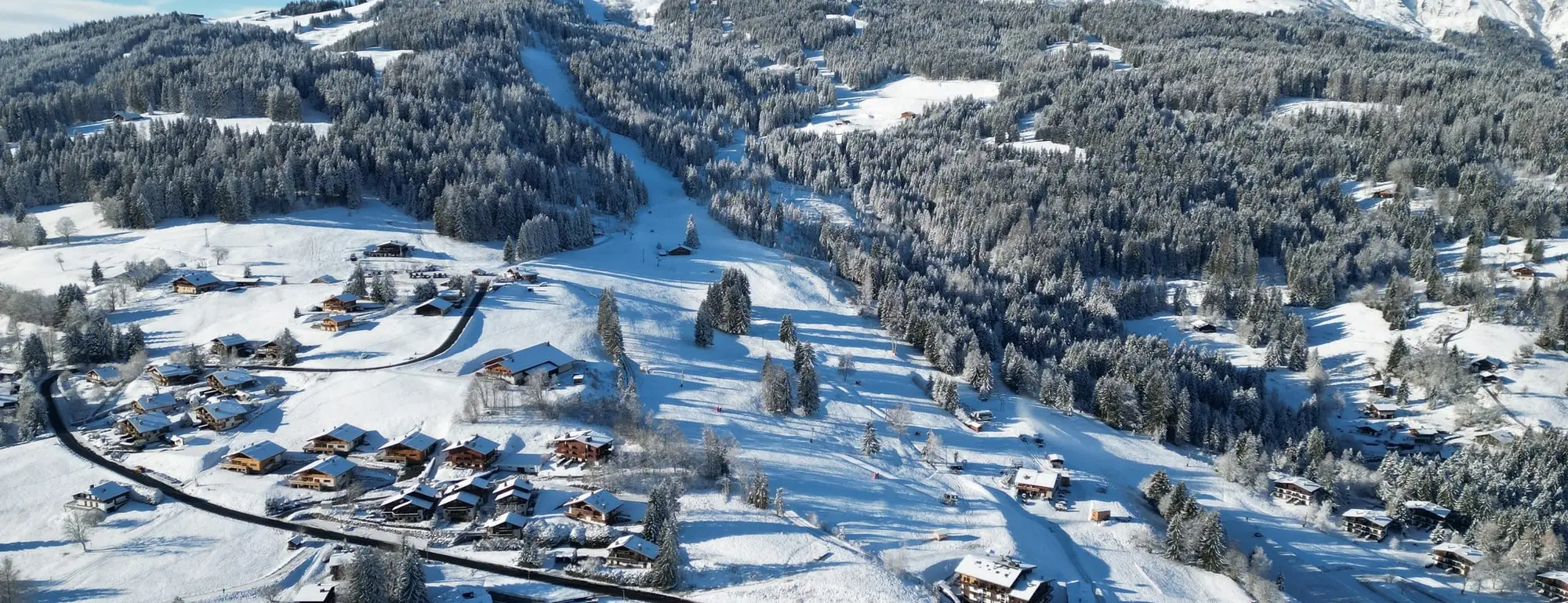 Vue aérienne du plateau de Combloux enneigé, les montagnes au loin