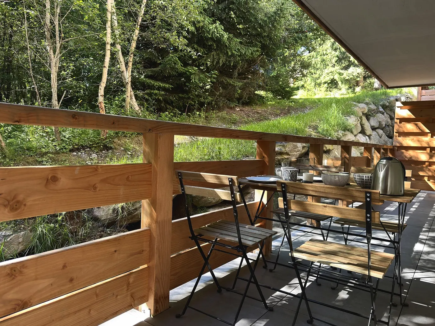Le balcon du T3, table et chaises face à la forêt