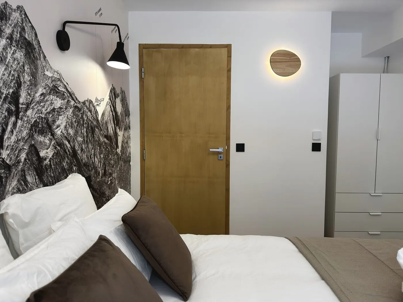 Le lit double de 160 × 200 et la fresque murale