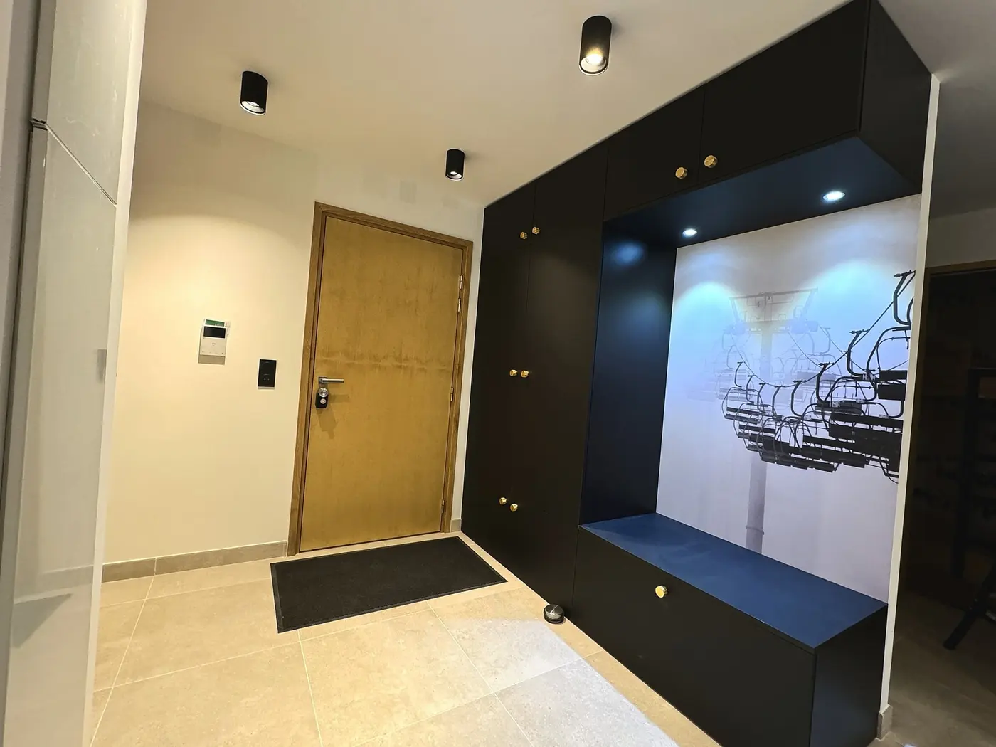 L'entrée du T3, avec son panneau noir et son banc de rangement