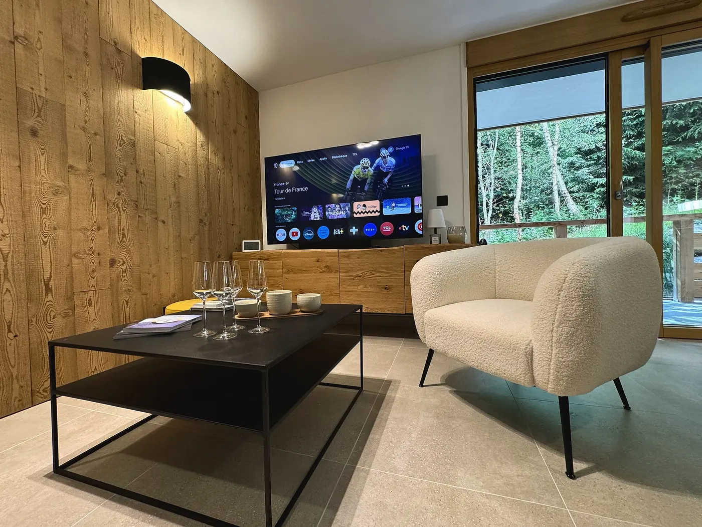 Le coin salon avec sa table basse, son fauteuil et le téléviseur