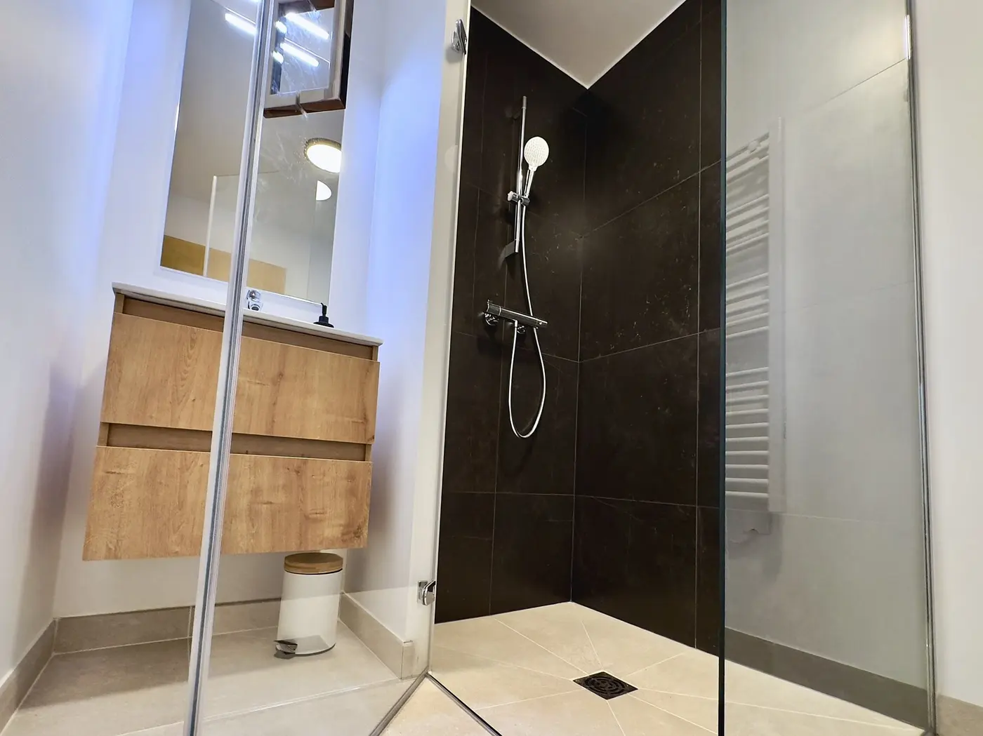 La salle de bain : douche à l'italienne carrelée et vasque bois